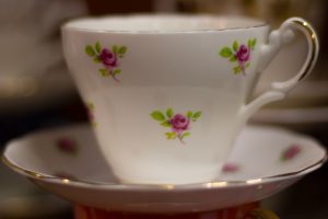 close up of white tea cup with rosebud pattern